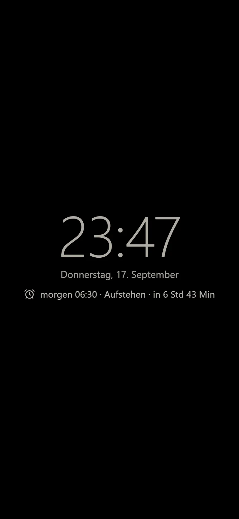 Nachttisch-Modus mit großer Uhr Nachttisch-Modus der Weckzentrale: große Uhrzeit, Wochentag mit Datum und der nächste Wecker auf dunklem Grund